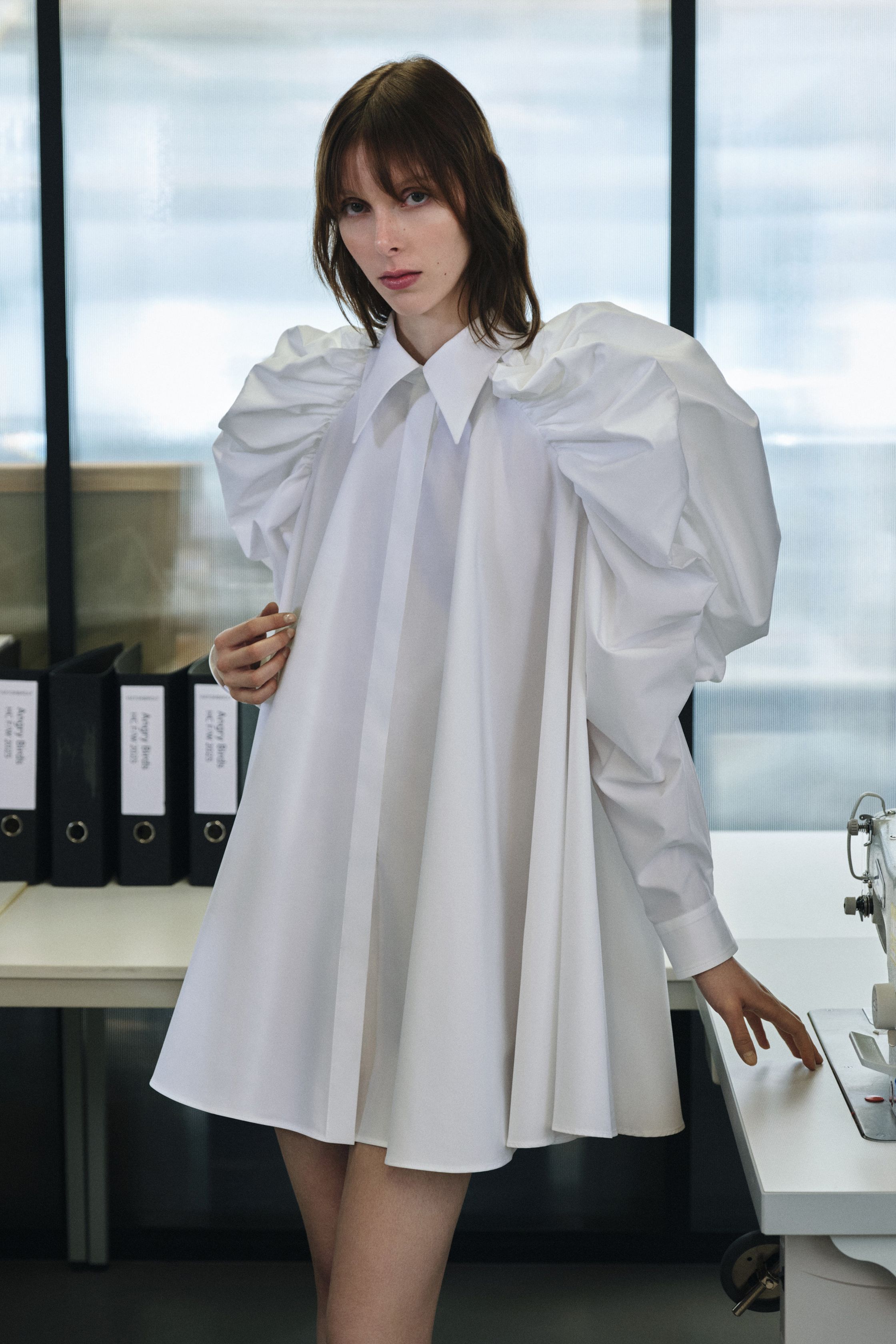 Viktor & Rolf 2026秋冬系列在工作室式场景中展现品牌经典的戏剧化设计。结构感皮革裙、夸张衬衫与建筑式廓形成为核心造型。设计师通过夸大的比例和利落剪裁，将传统时装结构进行艺术化演绎。整体风格在严谨与幽默之间取得平衡，展现品牌一贯的概念化时装语言-顽石频道趋势研究